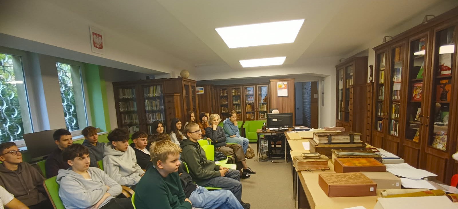 Uczniowie słuchający wykładu w bibliotece