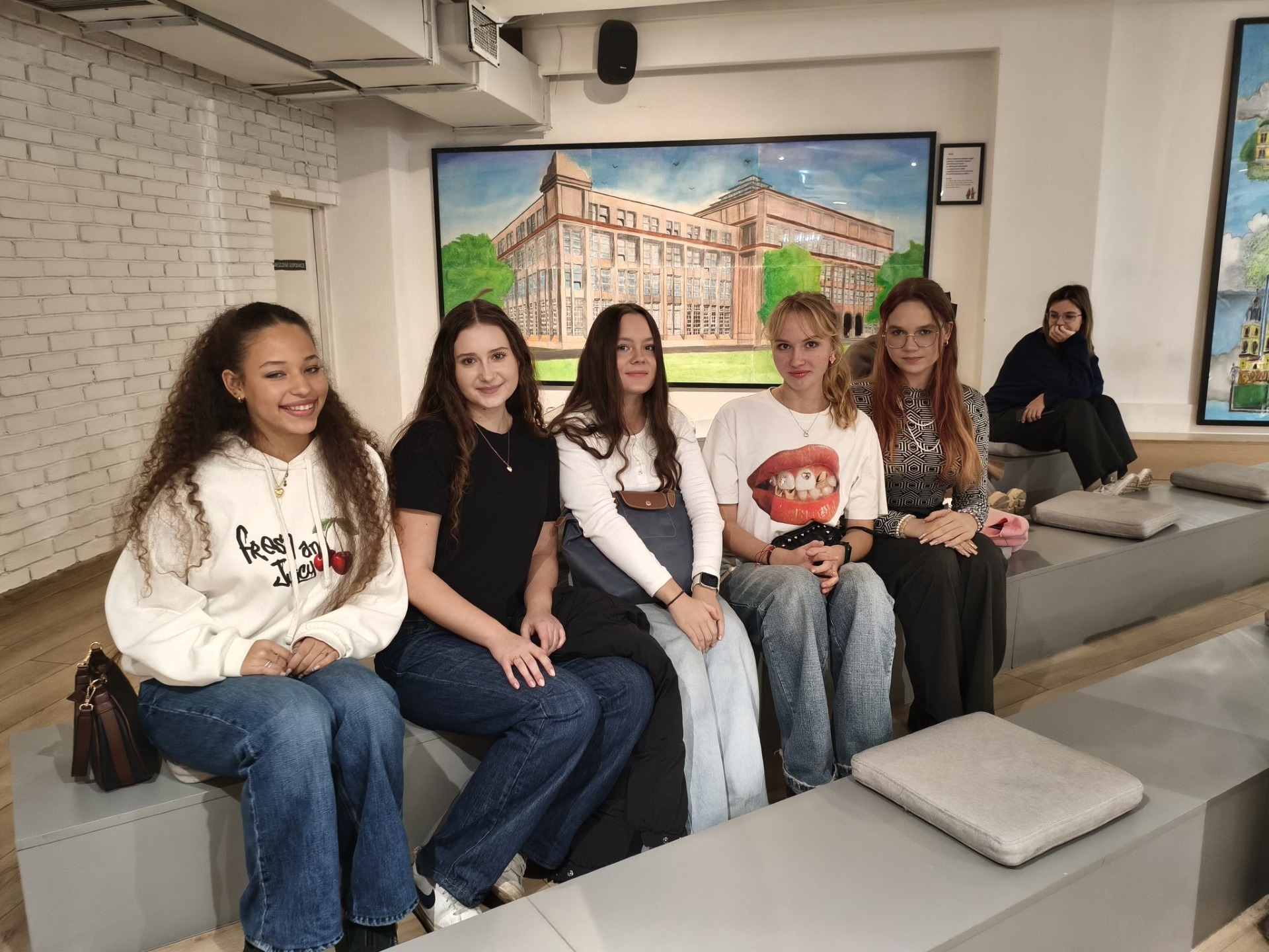 Kilka uczennic uczestniczących w wyciecze pozuje siedząc