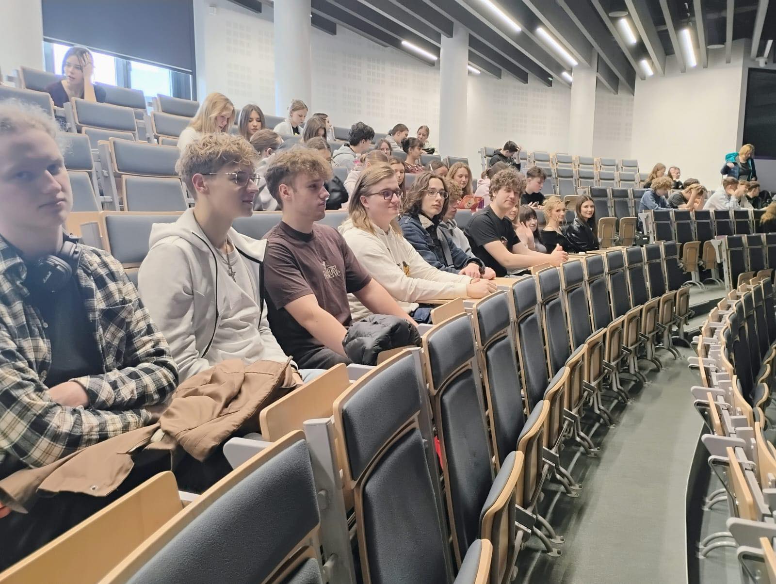 Uczniowie siedzący w auli uczelni