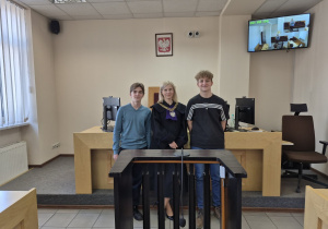 dwóch uczniów pozujących do zdjęcia z wykładowcą